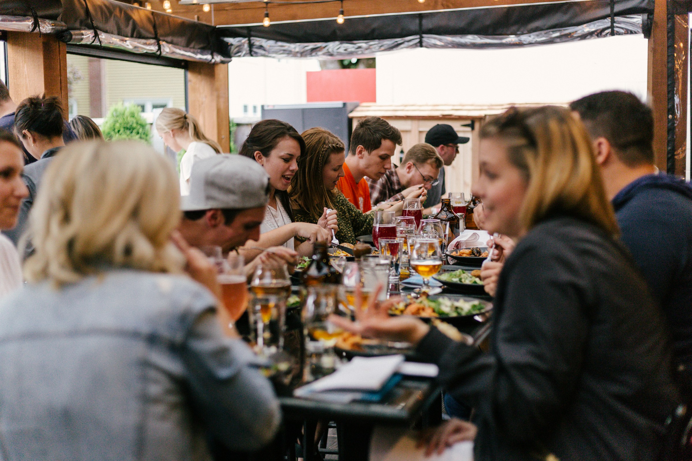 A group of friends sitting together at a table, talking and eating